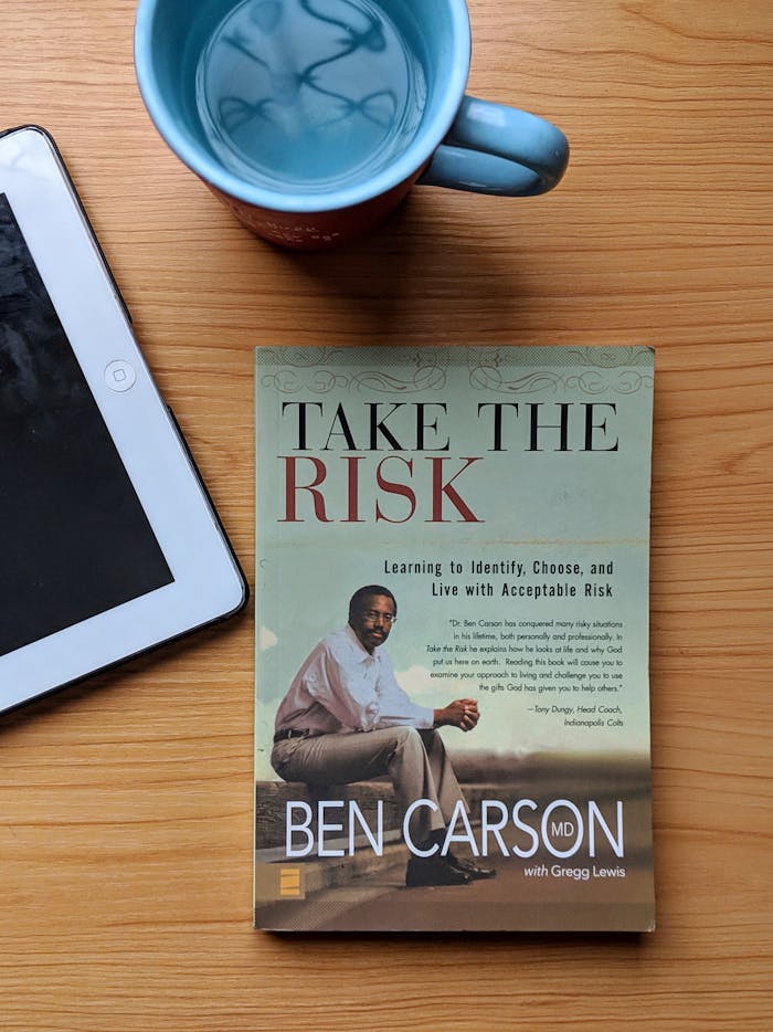 gallery-02 Top view of a Ben Carson book, tablet, and coffee mug on a wooden table.