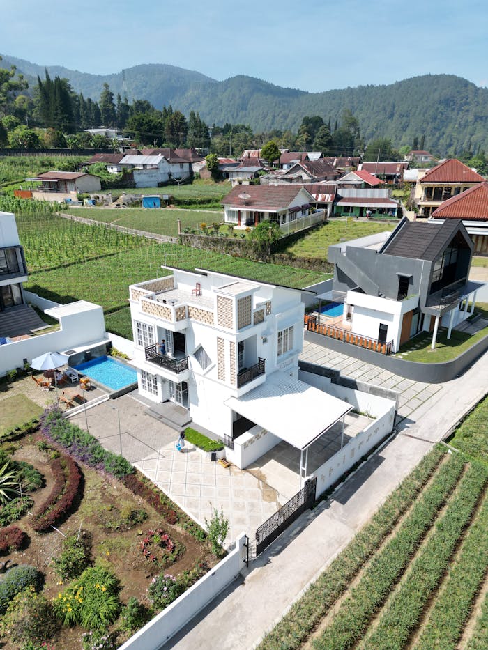 vision Aerial view of a modern home with pool and garden in a rural setting, surrounded by mountains.